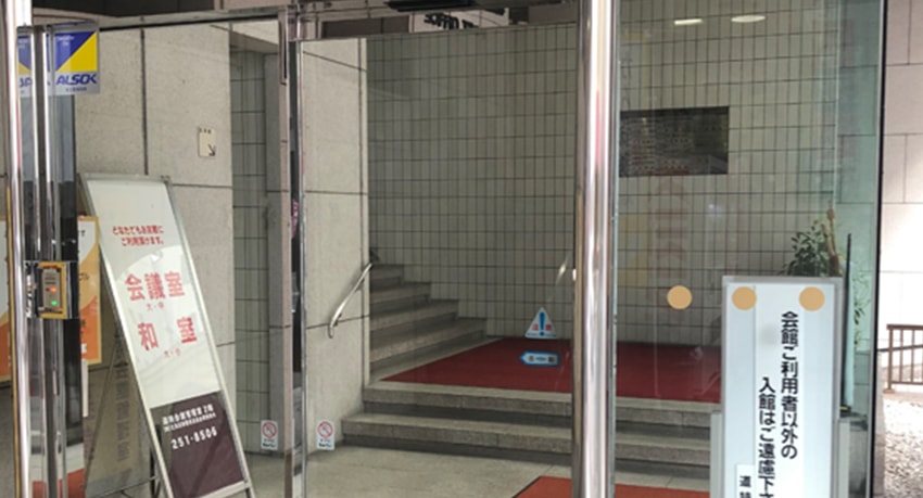 ⑥ここが入り口になります。階段を上って正面のエレベーターの6階で降りてください。右手の突き当りに事務所があります
